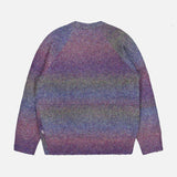 The LES DEUX Gradient Roundneck Knit Sweater, featuring long sleeves and a crew neckline, displays a multicolored gradient dyed pattern in shades of spiced plum, blue, and green, and is shown laid flat on a white background.