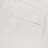 Close-up of the back of LES DEUX Patrick Linen-blend Pants, showcasing breathable light beige fabric, an elastic waistband, and a single welt pocket.