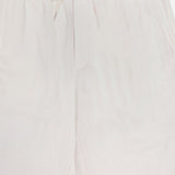 A close-up of the LES DEUX Patrick Linen-blend Pants, showcasing their breathable fabric, elastic drawstring waist, side pockets, and relaxed fit in light beige.