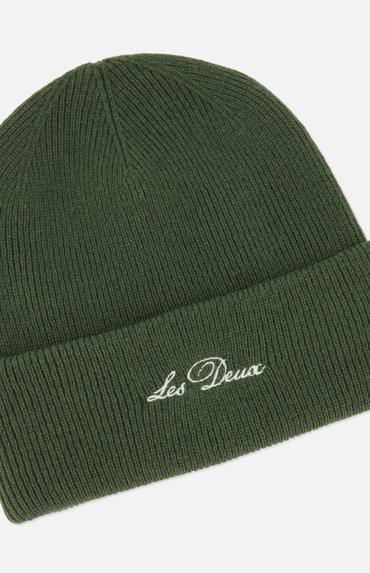 The Signature Logo Beanie by LES DEUX is a stylish green ribbed beanie featuring a folded brim for comfort. The front displays the LES DEUX logo embroidered in white cursive, making this classic wool beanie an essential addition to any wardrobe.