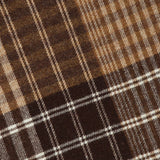 Close-up of the LES DEUX Signature Patchwork Check Scarf, showcasing intersecting horizontal and vertical lines in tan and cream that form a checkered pattern with varied shades and widths; crafted from soft wool, this scarf is finished with delicate fringe along the edge.