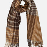 LES DEUX Signature Patchwork Check Scarf in brown and beige plaid, featuring fringe embellishment and a subtle embroidered signature on one side, displayed against a plain white background.