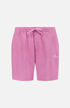 LES DEUX Stan Seersucker Swim Shorts are pink textured athletic swim shorts with a drawstring waist, side pockets, and a small white embroidered logo on the left leg.