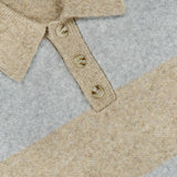 Close-up of the Striped Melange Knitted Polo Sweater by LES DEUX, featuring a collared neckline with three buttons and wide horizontal stripes in beige and gray melange. A white tag with text appears inside the collar, lending a classic, preppy finish to this stylish piece.