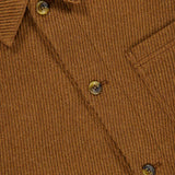 Close-up of the LES DEUX Twill Wool Overshirt for men, featuring a brown ribbed texture, classic collar, three-button placket, and a glimpse of the chest pocket. A partially visible label appears inside the collar.