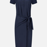 The Anthea Twist-front Midi Dress by LISA YANG, featuring a navy blue short-sleeve design with a buttoned neckline and matching fabric waist tie, showcases the elegant silhouette of a classic navy midi dress, displayed on a plain white background.