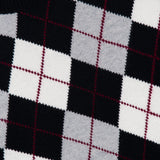 A close-up of the Antoni Cashmere Argyle Sweater by LISA YANG, showcasing its luxury black, white, and gray argyle pattern accented with thin red lines. Part of the garment’s label bearing the LISA YANG brand name is visible in the top left corner.