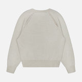 The Cambrie Crewneck Sweater by LISA YANG is shown from the back in beige, revealing its raglan sleeves and ribbed cuffs and hem against a plain white background—a refined staple that captures quiet luxury through its understated Scandinavian aesthetic.