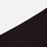 Close-up view of the LISA YANG Clare Cashmere Mini Skirt in black, highlighting the ribbed waistband and fine texture of the heavy knit cashmere fabric, angled diagonally across a white background.