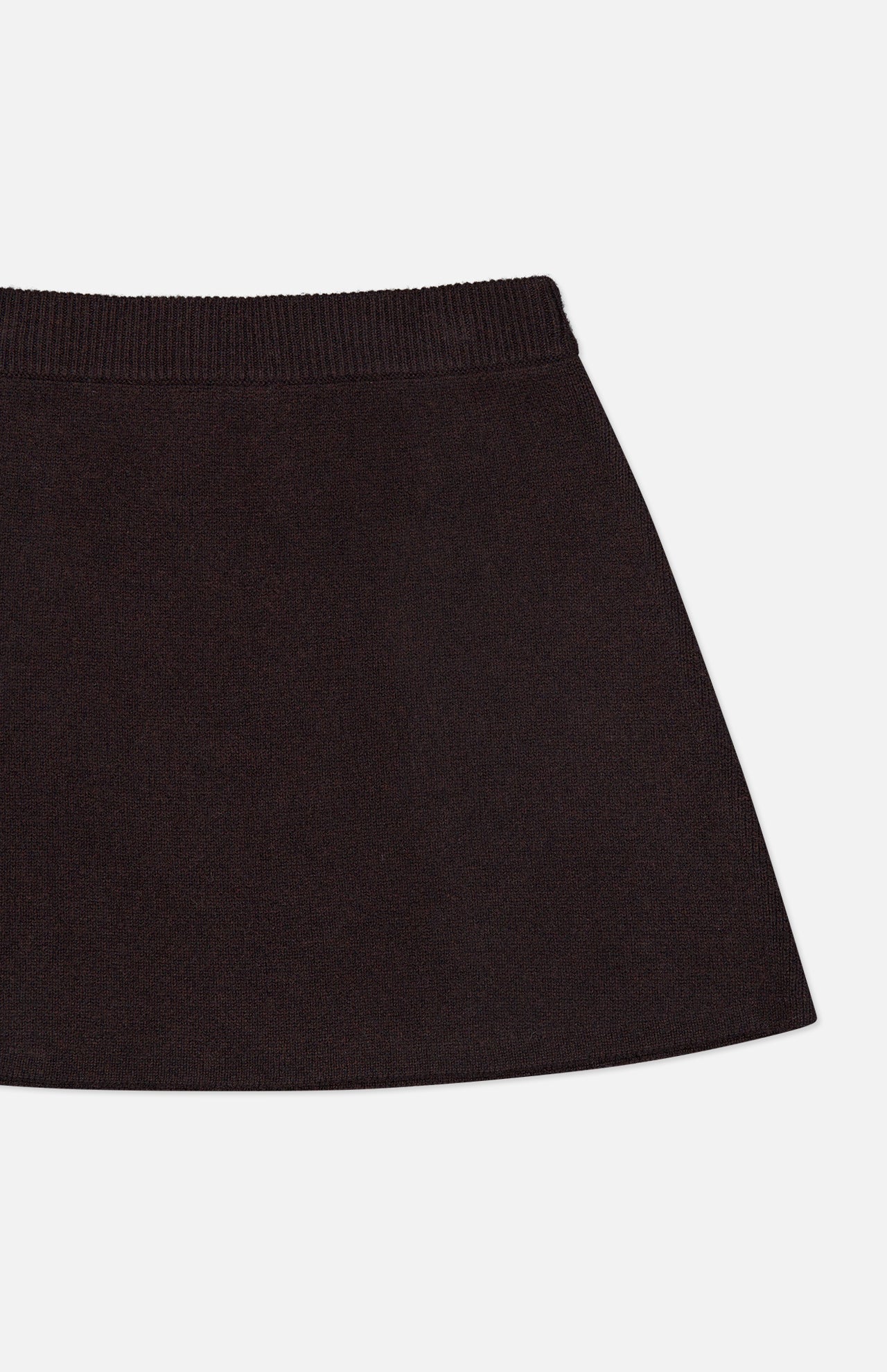 A close-up of the Clare Cashmere Mini Skirt by LISA YANG in black, showcasing its ribbed waistband and classic A-line silhouette against a white background. Crafted from soft, heavy knit cashmere, this skirt embodies the refined elegance and comfort characteristic of a slow luxury brand.