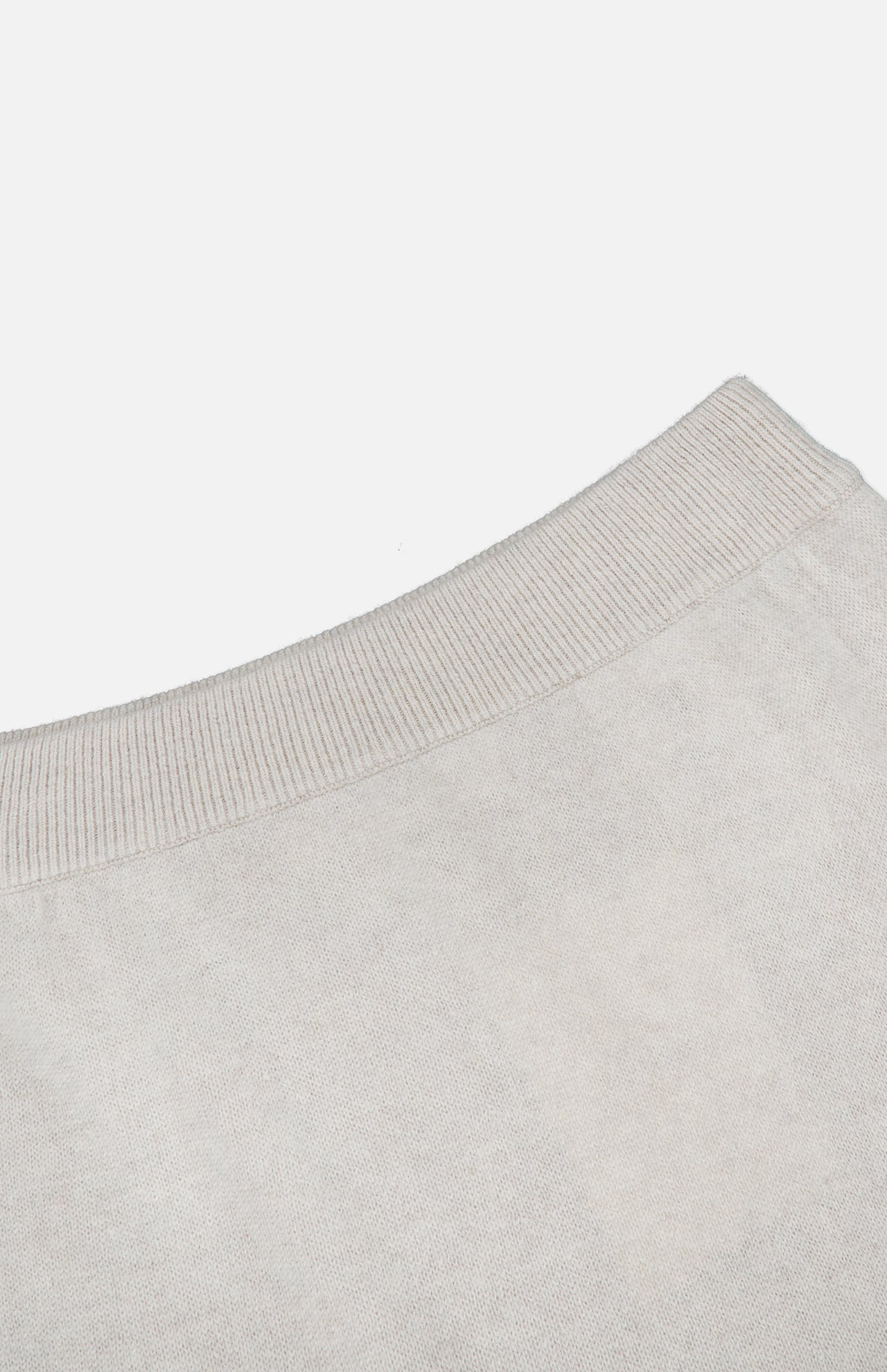 Close-up of the neckline of a light beige knit sweater, featuring ribbed trim detail against a plain white background—a perfect match for the LISA YANG Dolly Cashmere Maxi Skirt in light grey, creating an effortlessly refined look.