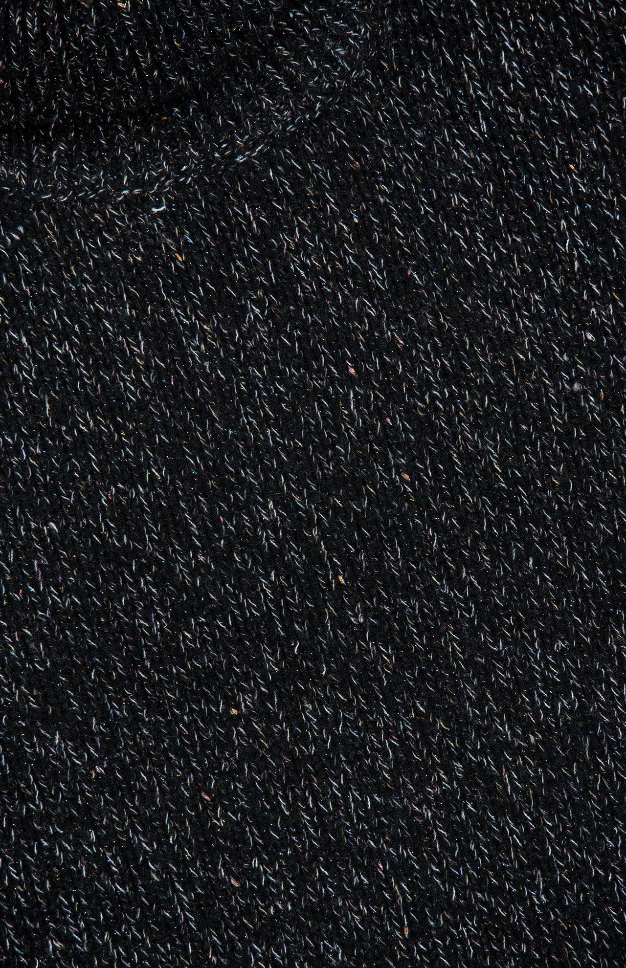 Close-up of the Femi Sparkle Turtleneck Sweater by LISA YANG, featuring dark, knitted luxury cashmere with a subtle textured pattern and small, multicolored fibers interwoven throughout the material, evoking a refined and sophisticated look.