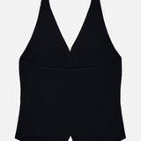 The Immy Halter Top by LISA YANG is a sleeveless black design inspired by a cashmere vest, featuring a deep V-neckline and a pointed front hem. Laid flat on a white background, this timeless piece embodies the essence of slow luxury.