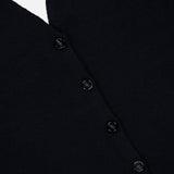 Close-up of the Immy Halter Top in black cashmere from LISA YANG, featuring five sleek black buttons arranged vertically and a partial view of a bottom pocket—a timeless piece from this slow luxury brand.