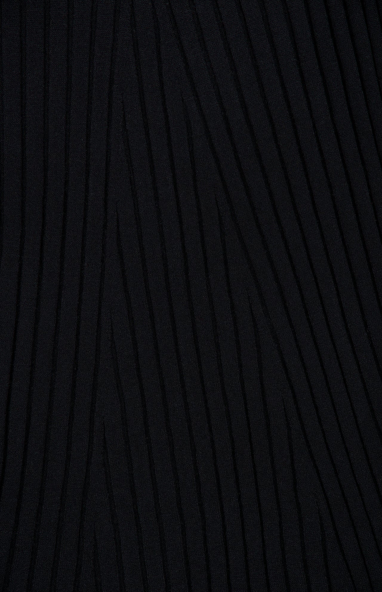 Close-up of the Isabela Maxi Dress by LISA YANG, featuring black knit fabric with a raised, wavy, linear texture running diagonally across the surface.