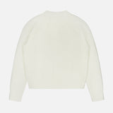 The LISA YANG Miki Cashmere Sweater, crafted from pure cashmere, is displayed laid flat on a white background. This luxury sweater showcases a ribbed texture and features a simple, classic design with long sleeves and a crew neckline in plain white.