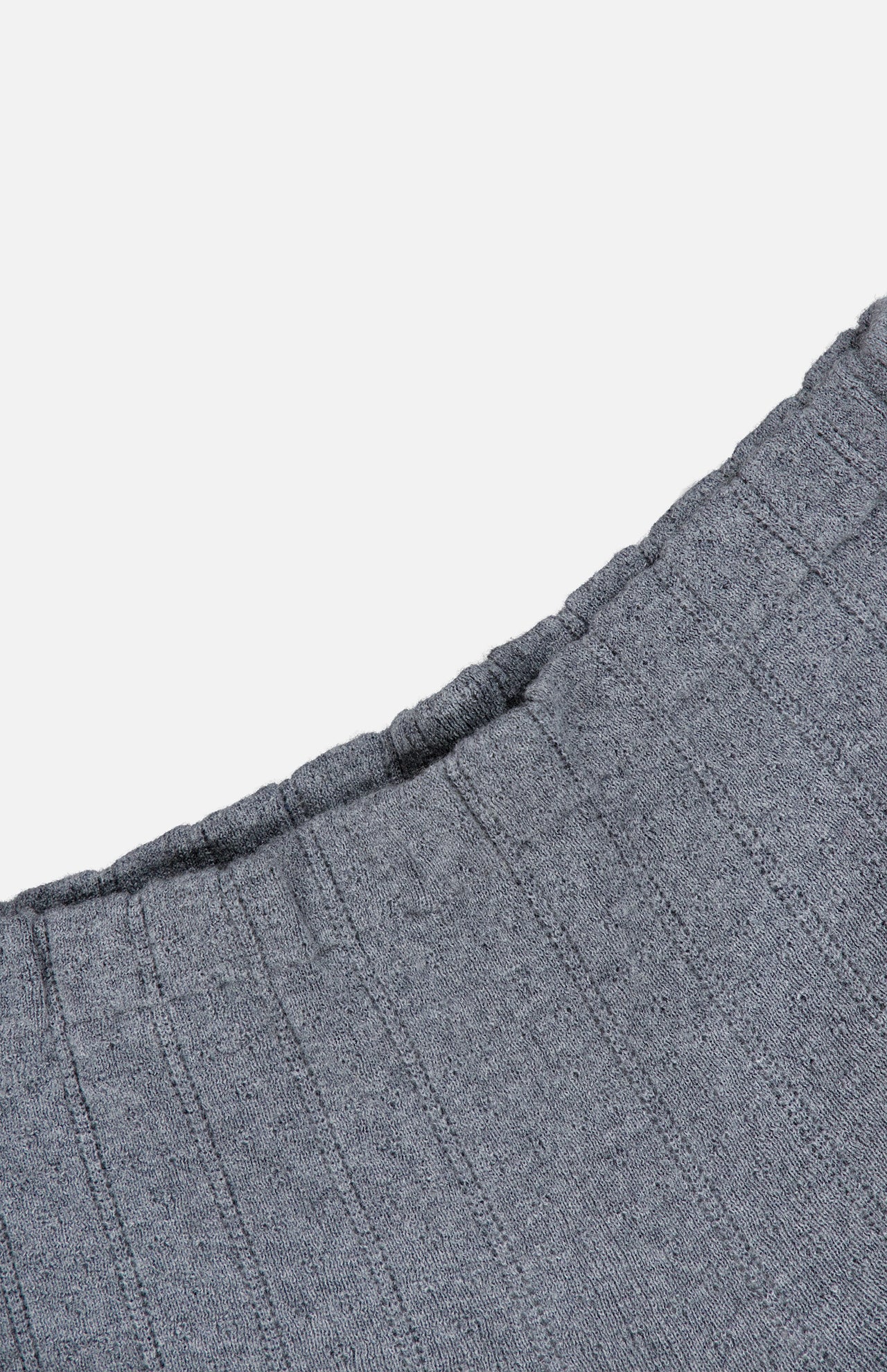Close-up of the Shannen Wide Leg Cashmere Pants by LISA YANG, showcasing the grey, ribbed knit fabric with a visible elastic waistband crafted from a soft cotton-cashmere blend, set against a plain white background.