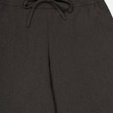 Close-up of the waistband of the LISA YANG Sofi Cashmere Drawstring Pant in dark brown, showcasing a ribbed, elastic band and a center-tied drawstring bow that captures Scandinavian style and the luxurious comfort of cashmere.