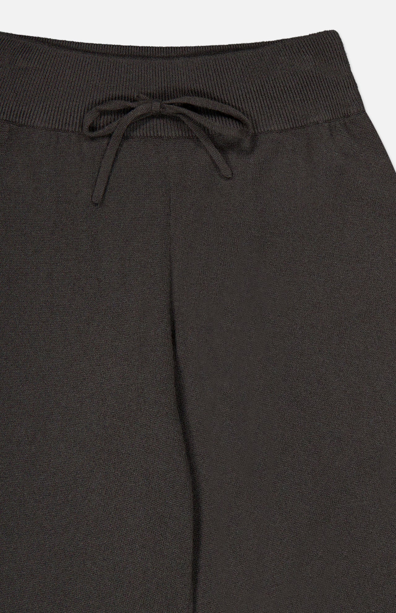 Close-up of the waistband of the LISA YANG Sofi Cashmere Drawstring Pant in dark brown, showcasing a ribbed, elastic band and a center-tied drawstring bow that captures Scandinavian style and the luxurious comfort of cashmere.