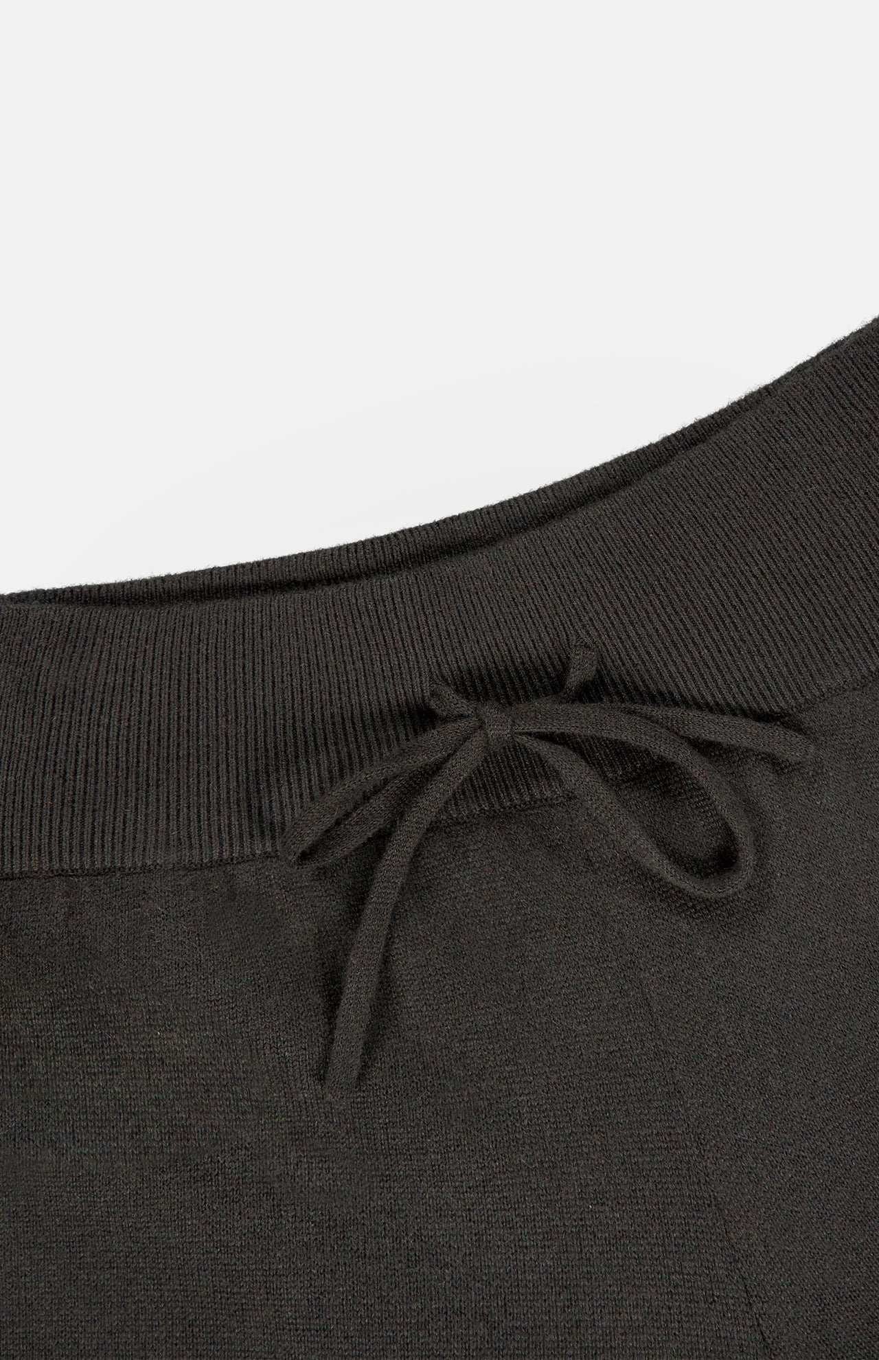 Close-up of the Sofi Cashmere Drawstring Pant by LISA YANG in black, showcasing an elastic waistband with a front drawstring bow. The texture of the cashmere fabric is visible, along with a partial pocket seam on the right side—an understated design that captures slow luxury and refined Scandinavian style.