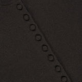 Close-up of the Wilona Cardigan Sweater, a luxury cashmere dark brown piece by LISA YANG, featuring a row of circular knit details along the front and a visible white label with the brand name.