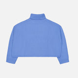 The Zerlina Turtleneck Sweater by LISA YANG—a cropped, long-sleeve, light blue cashmere turtleneck—laid flat on a white background and shown from the back. Crafted from luxurious cashmere, this elegant piece offers a soft and sophisticated touch.