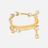 The LOGAN HOLLOWELL Gemini Constellation Ring showcases a modern open yellow gold design with two parallel bands linked by vertical bars, embellished with diamond accents and round clear gemstones.