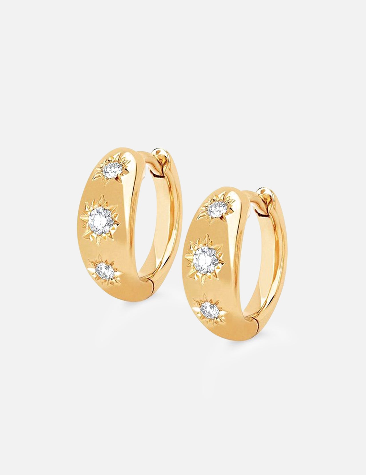 The LOGAN HOLLOWELL Three Star Set Rounded Diamond Huggie Earrings feature 14k gold hoops with three round diamonds in starburst patterns, a polished finish, and secure hinged closures.