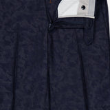 Experience unrivaled comfort and sophistication with the Malcom Wool Cashmere Camo Trouser Pant, expertly crafted in Italy. These dark blue luxury pants feature a subtle camo pattern and are shown partially unzipped and unbuttoned to highlight the detailed waistband, button closure, zipper, and the refined inside lining near the waistband.
