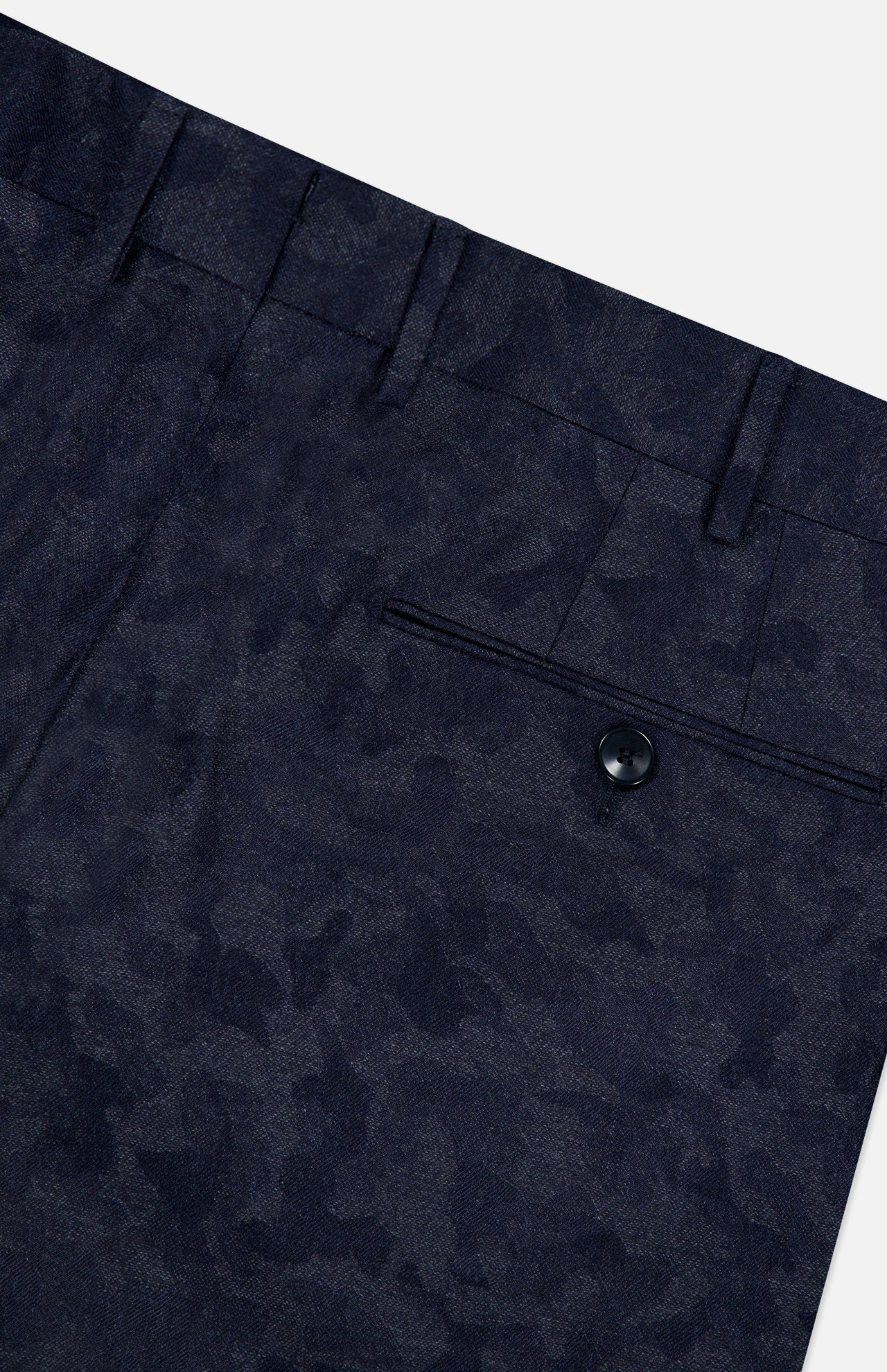 Close-up of Malcom’s Wool Cashmere Camo Trouser Pant in dark blue, featuring a refined camouflage pattern. The expertly crafted Italian design highlights a waistband with belt loops and a single back pocket fastened by a black button, blending sophistication and comfort in luxurious wool-cashmere fabric.