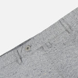 Close-up of the Malcom Wool Silk Donegal Trouser Pant in light grey, highlighting the speckled wool-blend fabric, waistband with button, belt loops, and a portion of the front pocket against a white background.
