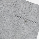 Close-up of the Malcom Wool Silk Donegal Trouser Pant in light gray, showcasing a buttoned back pocket, belt loops, and a subtle speckled Donegal pattern. The image is cropped to feature only the upper back section of these luxury trousers.