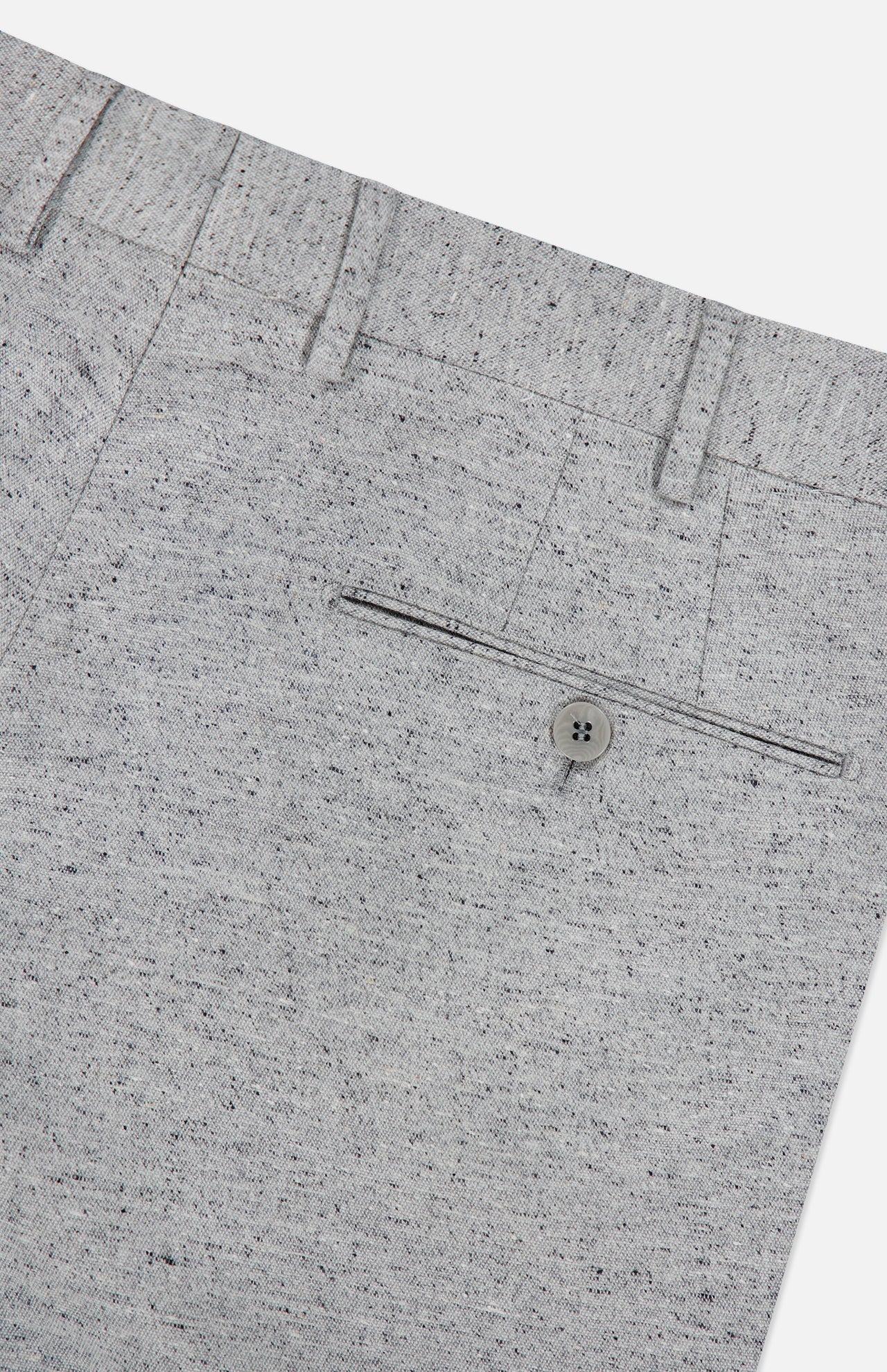 Close-up of the Malcom Wool Silk Donegal Trouser Pant in light gray, showcasing a buttoned back pocket, belt loops, and a subtle speckled Donegal pattern. The image is cropped to feature only the upper back section of these luxury trousers.