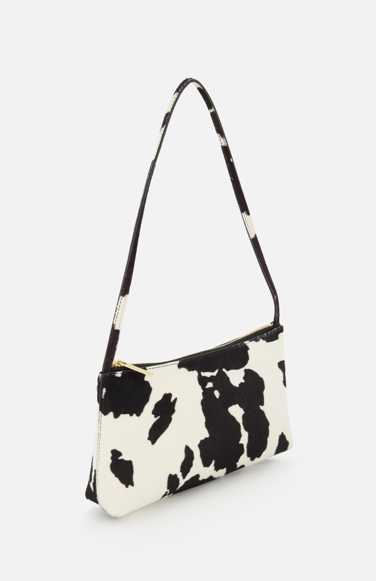 The MANSUR GAVRIEL Gaia Cow Print Shoulder Bag, featuring a black and white pattern, gold zipper closure, and matching strap, is displayed against a white background.