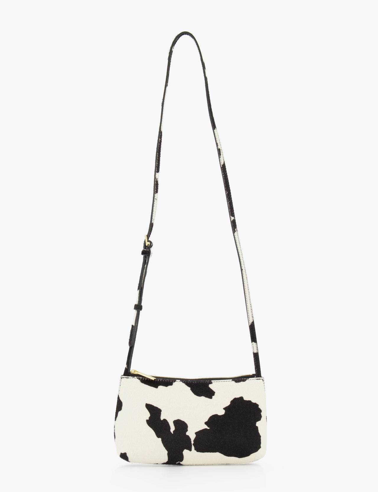 The MANSUR GAVRIEL Mini Gaia Cow Print Crossbody Bag features a black and white cow pattern, a small rectangular shape, and a long adjustable strap, showcased against a plain white background.