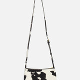 The MANSUR GAVRIEL Mini Gaia Cow Print Crossbody Bag features a black and white pattern, single adjustable strap, and rectangular shape—a stylish mini purse shown against a plain white background.