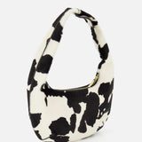 The MANSUR GAVRIEL Mini Gnocchi Cow Print Bag is a small, crescent-shaped hobo with a black and white pattern, zippered top, and single handle.
