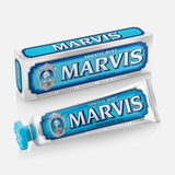 A box and tube of MARVIS Aquatic Mint Toothpaste, both featuring blue and white packaging with a vintage design and a portrait, are displayed on a white background. This premium toothpaste embodies the classic Italian tradition with its refreshing Aquatic Mint flavor.