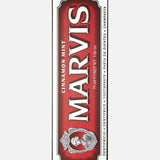 Box of MARVIS Cinnamon Mint Toothpaste, 75 ml (3.8 oz), set against a red background with silver trim. This premium Italian toothpaste displays the MARVIS logo and an ornate emblem on the front of the packaging, emphasizing its unique cinnamon mint flavor.