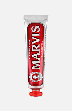 A red and silver tube of MARVIS Cinnamon Mint Toothpaste stands upright with a red cap, showcasing ornate design elements and bold white text on the front—an Italian luxury toothpaste that offers a uniquely refreshing cinnamon mint flavor.