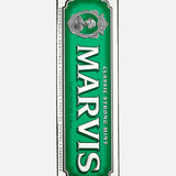 A box of MARVIS Classic Strong Mint Toothpaste featuring a green and white design with the brand name and a vintage-style illustration above the text. This Italian-made toothpaste offers a concentrated formula for an invigorating clean.