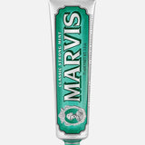 A silver and green tube of MARVIS Classic Strong Mint Toothpaste stands upright with the cap at the bottom. This Italian-made toothpaste features a concentrated paste formula and displays the MARVIS logo along with product details.