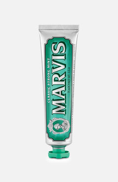 A silver and green tube of MARVIS Classic Strong Mint Toothpaste stands upright with the cap at the bottom. This Italian-made toothpaste features a concentrated paste formula and displays the MARVIS logo along with product details.