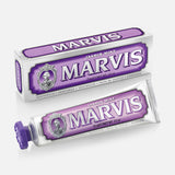 A box and tube of MARVIS Jasmin Mint Toothpaste are pictured. Both feature purple and silver vintage-style packaging with a portrait logo, representing the Italian-made luxury toothpaste from MARVIS; the tube rests in front of its matching box.