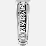 A tube of MARVIS Whitening Mint Toothpaste stands upright on a white background. This Italian-made toothpaste comes in a metallic silver tube adorned with black and white text and decorative details, providing an elegant solution for teeth whitening.