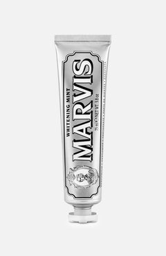 A tube of MARVIS Whitening Mint Toothpaste stands upright on a white background. This Italian-made toothpaste comes in a metallic silver tube adorned with black and white text and decorative details, providing an elegant solution for teeth whitening.