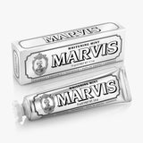 A tube and box of MARVIS Whitening Mint Toothpaste are pictured. This Italian-made toothpaste features white packaging with black text and decorative details. The tube displays the product name "Marvis Whitening Mint Toothpaste" along with "75 ml / 3.8 oz.", emphasizing its teeth whitening formula.