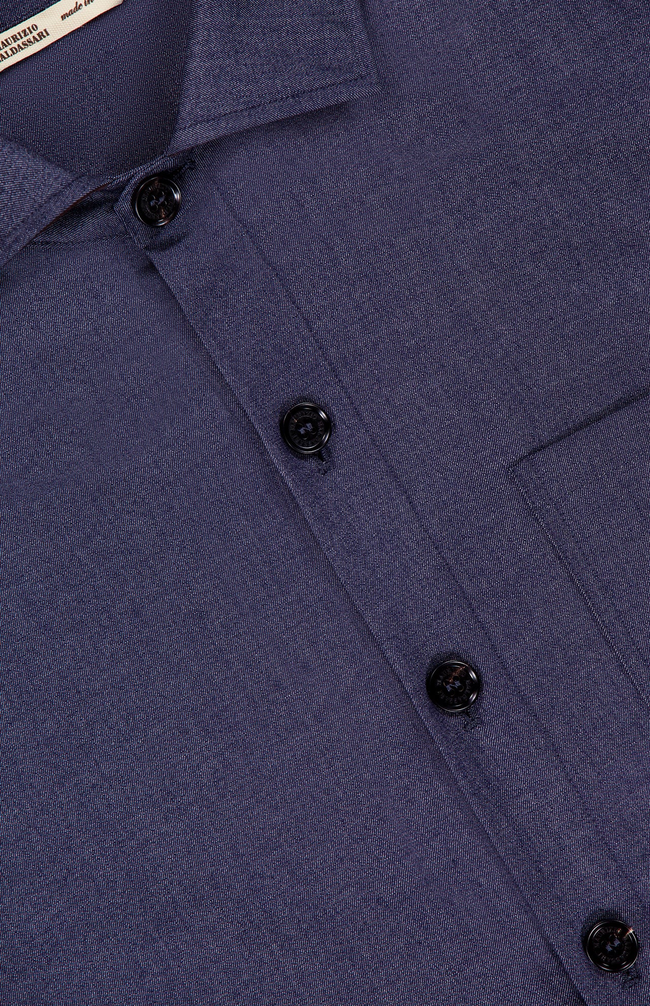 Close-up of the Light Classic Overshirt by MAURIZIO BALDASSARI, made in Italy. This dark blue piece features black buttons, a visible right chest pocket, and subtly textured fabric.