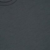 A close-up of a dark gray Linate Short Sleeve T-Shirt by MAURIZIO BALDASSARI, featuring part of the collar and the brand label with gold lettering inside the neckline, highlighting its Made in Italy craftsmanship.