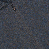 Close-up of a blue and brown mottled Maurizio Baldassari Mouline Zipped Knit Overshirt in virgin wool, featuring a zip-up front and a ribbed collar.